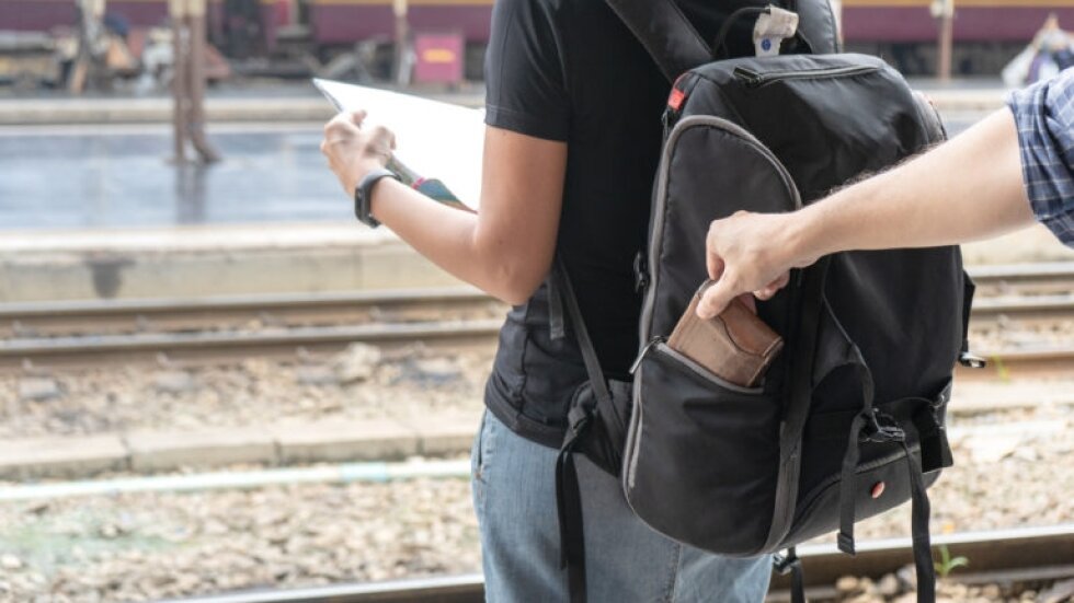 Street thief stealing a wallet from woman tourist backpack